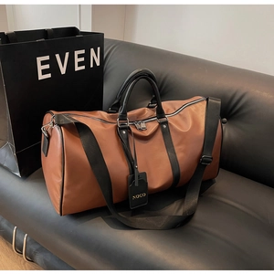 Detailed view of brown travel bag texture with black handles on a black leather sofa