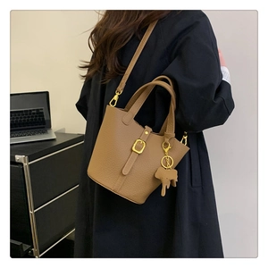 Detailaufnahme der braunen Bucket Bag aus strukturiertem Leder mit goldenen Elementen