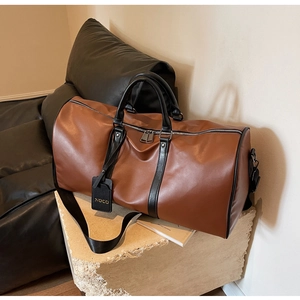 Macro view of brown leather texture and NOCO gold stamped tag on large travel bag