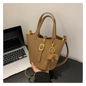 Nahaufnahme der braunen Bucket Bag aus Leder mit goldener Schnalle und Elefantenanhänger