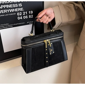Detail der schwarzen Boston-Tasche aus Wildleder und Mattleder mit goldenem Reißverschluss