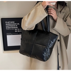 Detailansicht der schwarzen gesteppten Nylon-Tragetasche mit glänzendem Finish