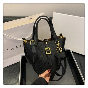Detail der schwarzen Bucket Bag aus Leder mit goldener Schnalle und Elefantenanhänger