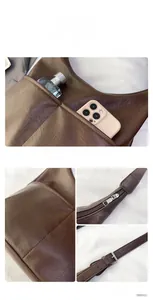 Détail d'un sac seau vintage en cuir marron montrant la bandoulière et la poche