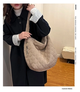Detail view of beige quilted tote bag with fan-shaped stitching and metallic zipper