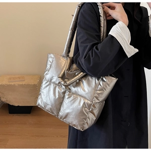 Detail der übergroßen gesteppten Puffer-Tasche in Silber mit Metallic-Finish und breitem Gurt