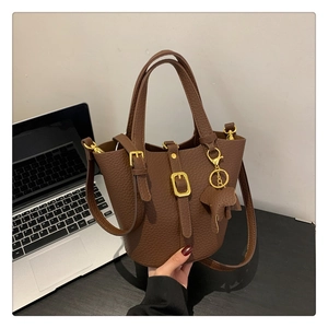 Detailansicht einer braunen Bucket-Bag aus Leder mit einem süßen Elefantenanhänger