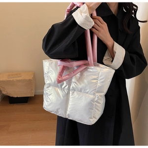 Detail der großen silbernen Stepptasche mit rosa gepolsterten Tragegriffen für den Herbst