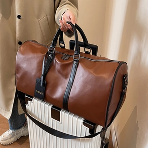 Large capacity dark brown leather travel bag on white suitcase with adjustable strap