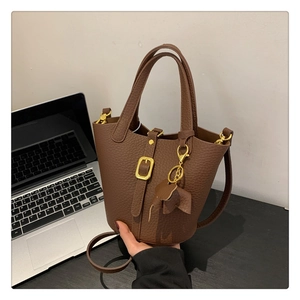 Detail der dunkelbraunen Lederbeuteltasche mit Goldhardware und Elefantenanhänger