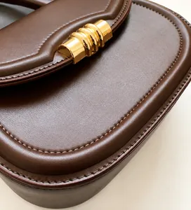 Detailed macro view of high-quality brown leather texture and gold metal buckle hardware