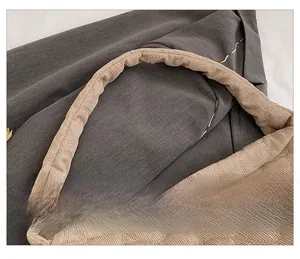 Close-up of padded shoulder strap on beige quilted tote bag with bubble fabric texture