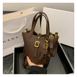 Nahaufnahme der dunkelbraunen Lederbeuteltasche mit Goldbuckle und Elefantenanhänger