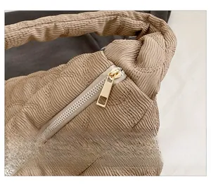 Close-up of smooth gold zipper and unique bubble crinkle texture on khaki canvas tote bag