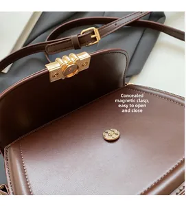 Detail of dark brown saddle bag featuring hidden magnetic buckle and adjustable strap