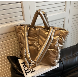 Detailaufnahme der champagnergoldenen gesteppten Tragetasche mit Metallic-Textur