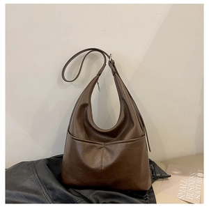 Gros plan d'un sac hobo marron foncé avec grande poche frontale et bandoulière