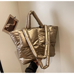 Detailansicht der gesteppten Puffer-Tragetasche in Gold-Metallic mit breitem Schultergurt