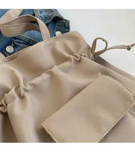 Detail view of beige canvas bucket bag featuring drawstring closure and flap pocket