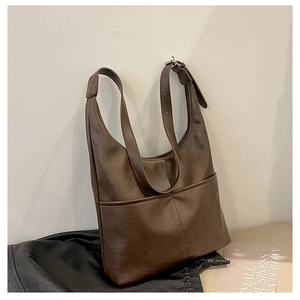 Détails macro d'un sac cabas rétro marron foncé avec deux poches et boucles argentées