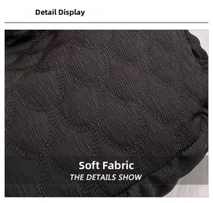 Detailed close-up of soft black quilted fabric with elegant scalloped pattern texture