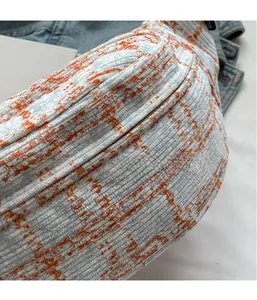 Close-up of light blue and orange checkered corduroy fabric with metal zipper detail