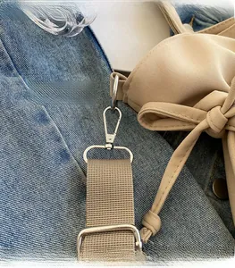 Detail of beige tote bag with premium silver hook and adjustable canvas strap