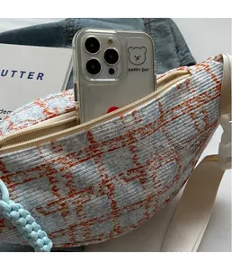 Detail of tweed crossbody bag interior showing spacious storage for a smartphone