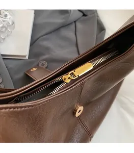 Detail view of brown leather tote with premium gold zipper and magnetic closure