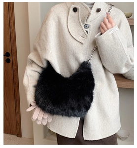 Détail du sac seau en fausse fourrure noire avec chaîne à billes argentée sur manteau