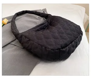 Detail of black corduroy tote bag featuring a stylish wavy quilted pattern and wide strap