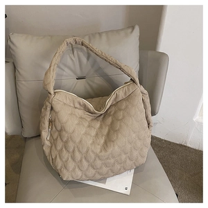 Detailed close-up of beige quilted hobo bag with fish scale texture and gold zipper
