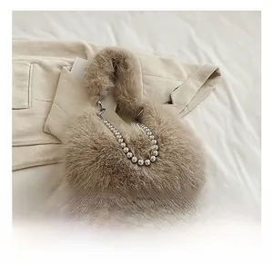Détail du sac seau en fausse fourrure duveteuse avec poignée perlée argentée et fermoir
