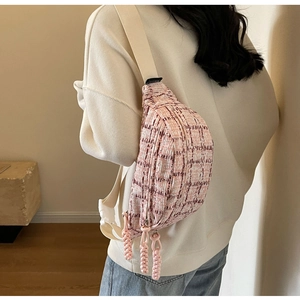 Detailed view of pink and white checkered tweed crossbody bag with woven zipper tassels