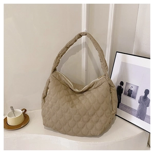 Detail of khaki quilted canvas hobo bag with zip closure and wide shoulder strap
