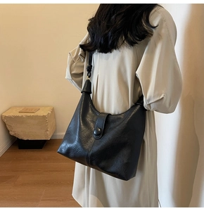Detail view of the black retro hobo bag showing its leather texture and thick strap