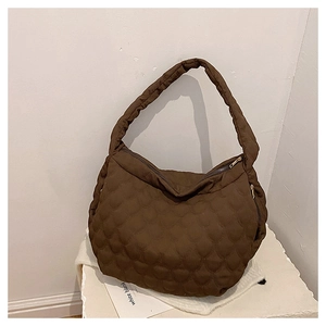 Detail of dark brown quilted tote bag with smooth texture and sturdy shoulder strap