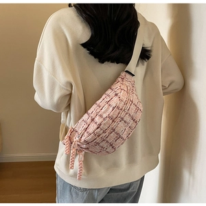 Pink plaid tweed crossbody bag shown on a model with adjustable cream strap details