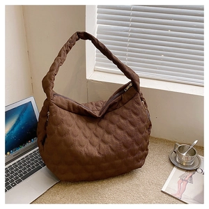 Detail of coffee brown quilted tote bag with water-drop stitching and metal zipper
