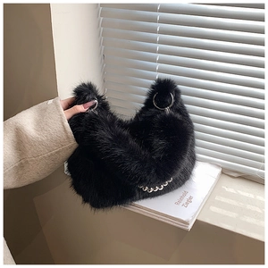 Détail du sac seau en fausse fourrure noire avec poignée en métal argenté et chaînette