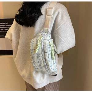 Detail view of large capacity corduroy crossbody bag with woven zipper and strap buckle