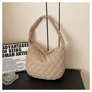 Detail of khaki quilted nylon tote bag with unique scallop stitching and zipper closure