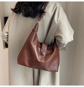 Detail showing the retro brown faux leather texture and elegant buckle of the tote bag