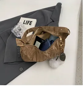 Intérieur spacieux du sac plissé marron montrant une grande capacité d'objets divers