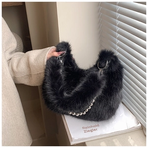 Détail d'un sac seau en fausse fourrure noire avec poignée chaîne à billes argent