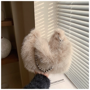 Détail de la texture en fausse fourrure et chaîne à billes du sac seau beige
