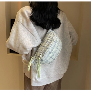Detail of tweed crossbody chest bag with blue and green plaid and zipper detail