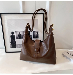 Detailed texture of dark brown PU leather tote bag with elegant flap buckle and slim straps