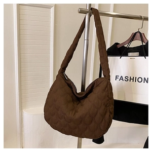 Detailed close-up of dark brown quilted crescent bag on a metal display rack