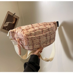 Detail of pink and cream tweed crossbody bag with adjustable strap and braided zippers